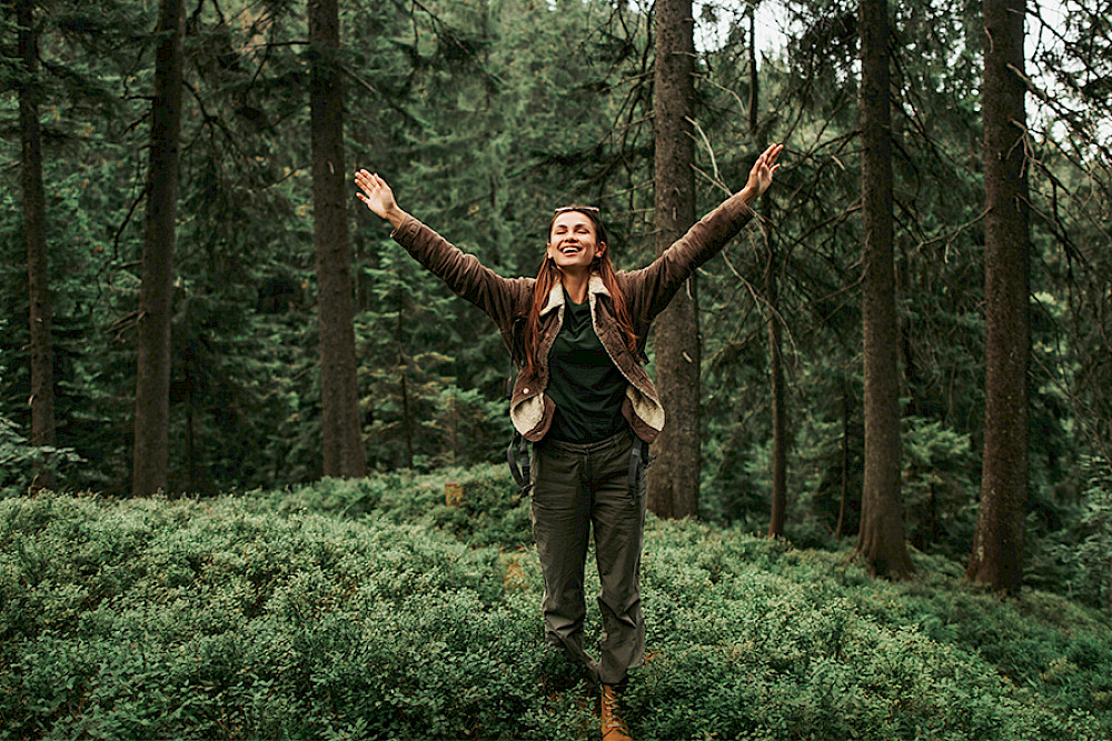 Bild zeigt eine Frau im Wald.