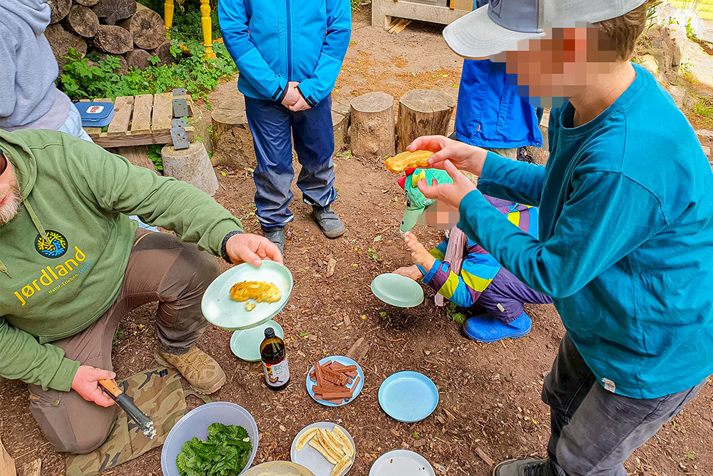 Bild zeigt Kinder beim Essen überm Feuer.