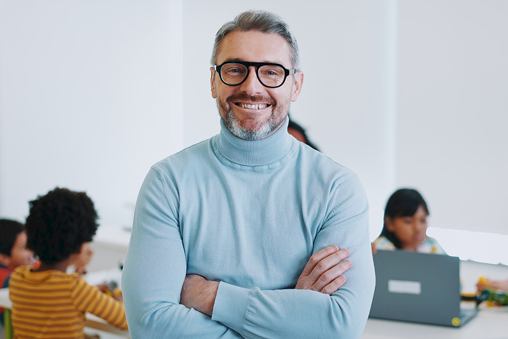 Bild zeigt einen Lehrer mit seiner Schulklasse.