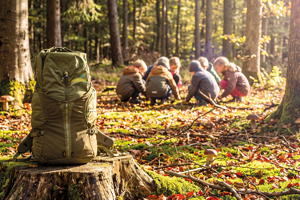Bild zeigt den Raido-Rucksack und Kinder im Wald.